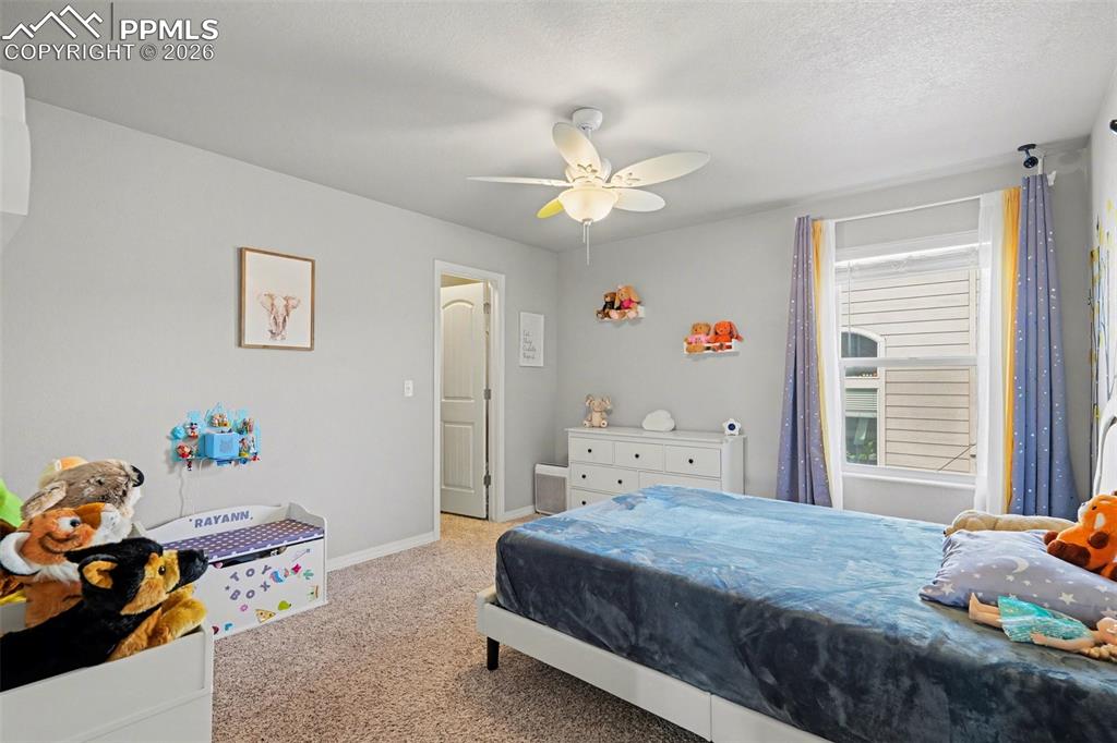 Image 15 of 40: Carpeted room featuring a ceiling fan, a window with blinds, and light gray