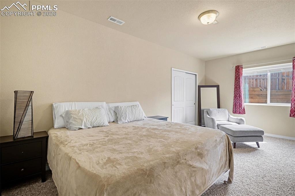 Image 16 of 40: Carpeted room featuring a white paneled door, a horizontal window, and a fl