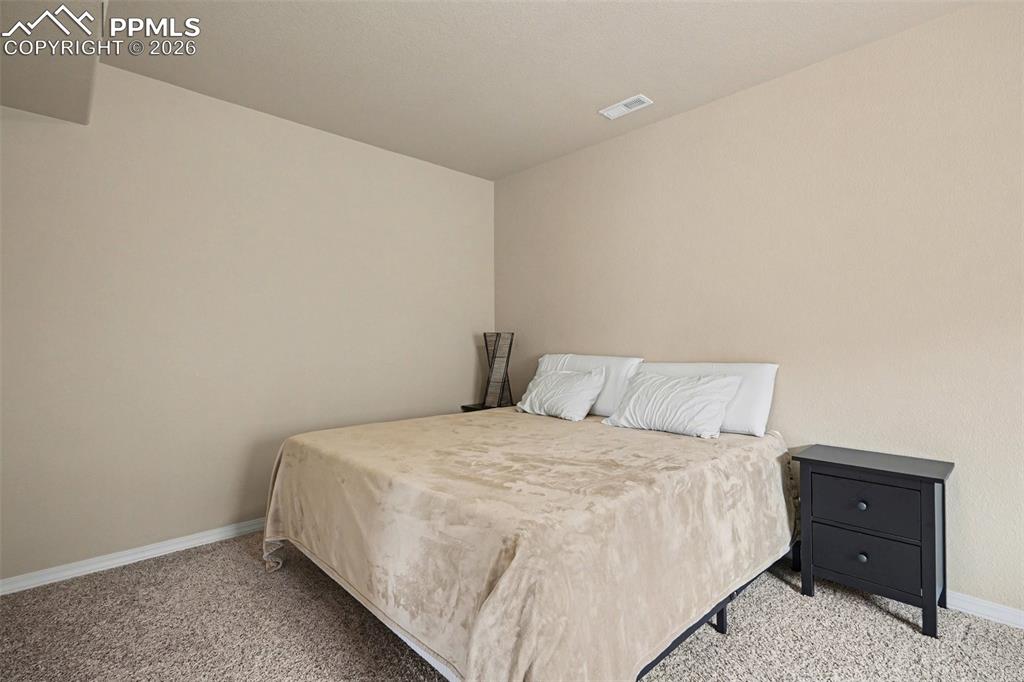 Image 17 of 40: Carpeted room featuring neutral wall tones and a ceiling-mounted register