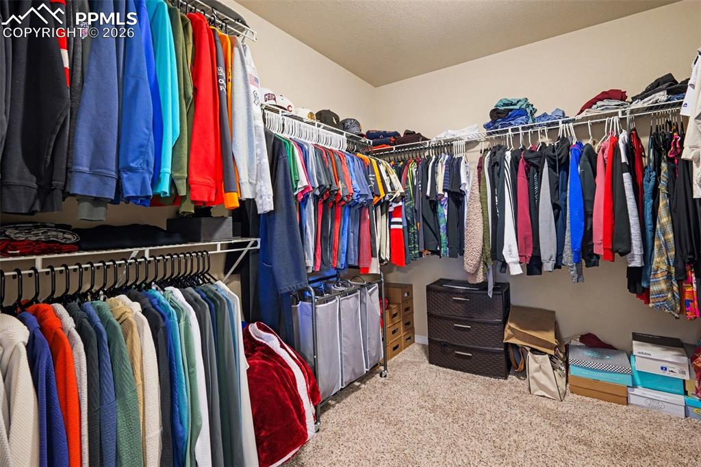 Image 29 of 40: Walk-in closet featuring extensive wire shelving and multiple hanging rods 