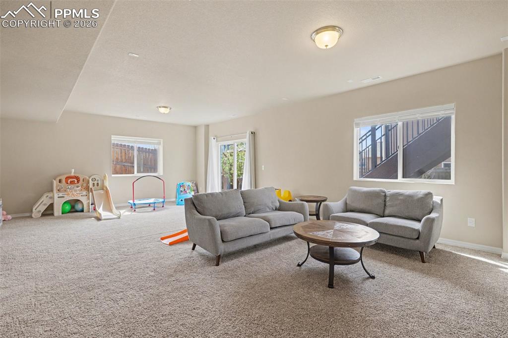 Image 31 of 40: Spacious carpeted room featuring multiple windows, recessed lighting, and a
