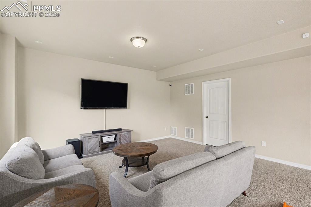 Image 32 of 40: Carpeted room featuring light beige walls and a white paneled door