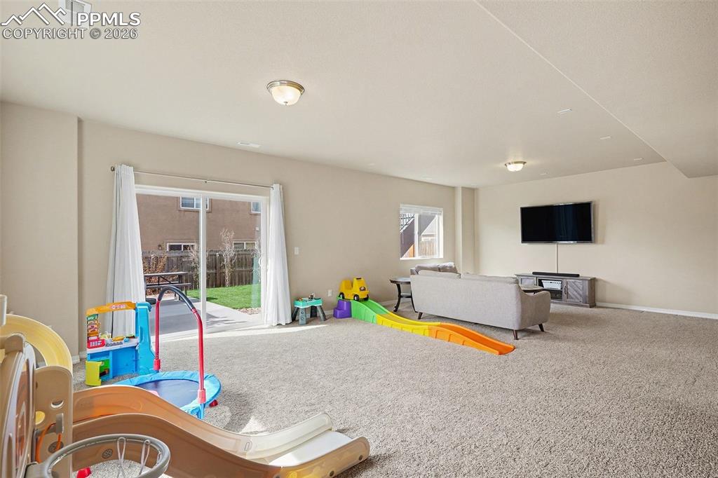 Image 33 of 40: Spacious carpeted room featuring a sliding glass patio door, flush-mount ce