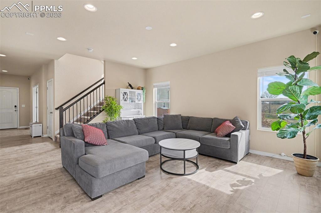 Image 6 of 40: Spacious living area featuring wood-finish flooring, recessed lighting, and