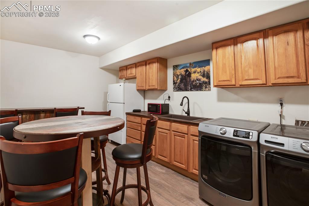 Image 23 of 34: The laundry room/lower level kitchenette-- everyone wants