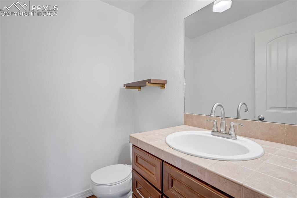 Image 15 of 50: Half bath featuring vanity and toilet