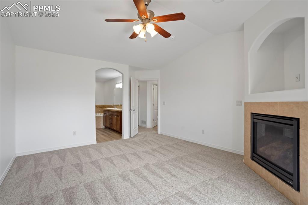 Image 18 of 50: Unfurnished living room with light colored carpet, arched walkways, lofted