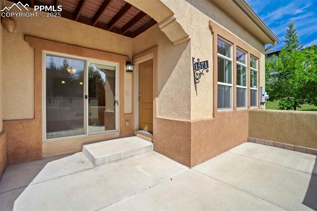Image 2 of 50: Entrance to property featuring stucco siding and a patio
