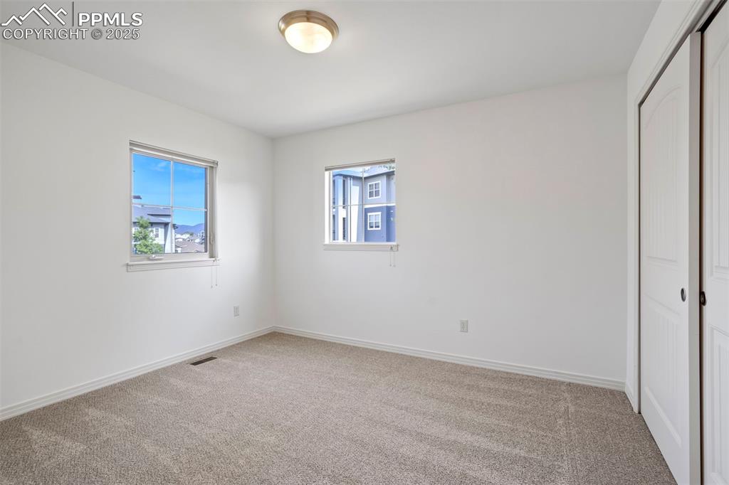 Image 25 of 50: Unfurnished bedroom with light colored carpet and a closet