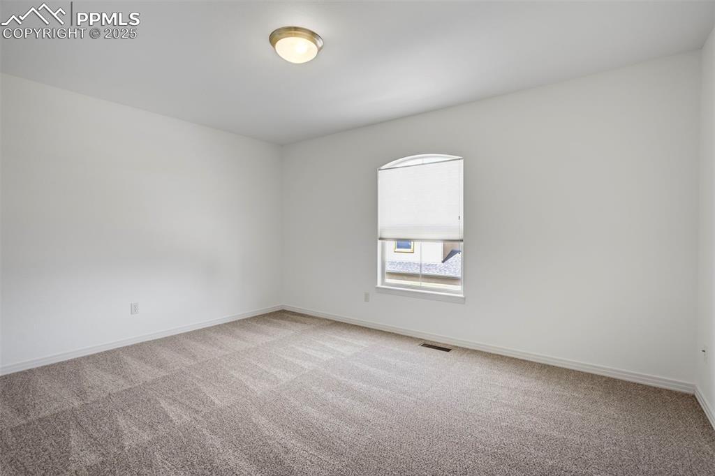 Image 29 of 50: Empty room with light colored carpet and baseboards