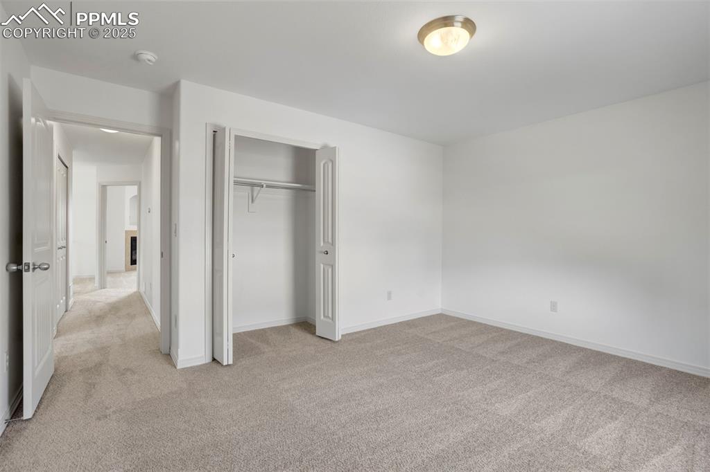 Image 30 of 50: Unfurnished bedroom with light carpet and a closet