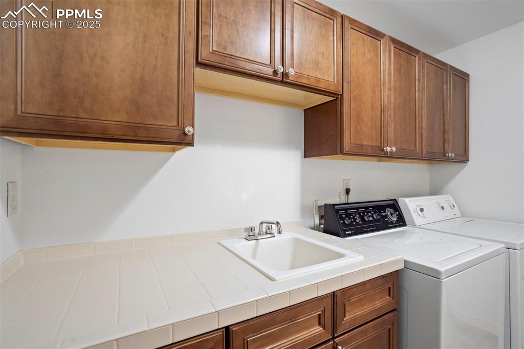 Image 35 of 50: Laundry room with cabinet space and separate washer and dryer