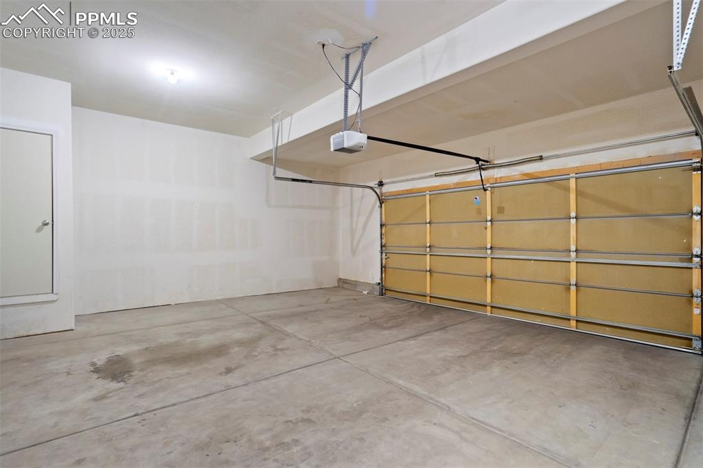 Image 36 of 50: Garage featuring a garage door opener