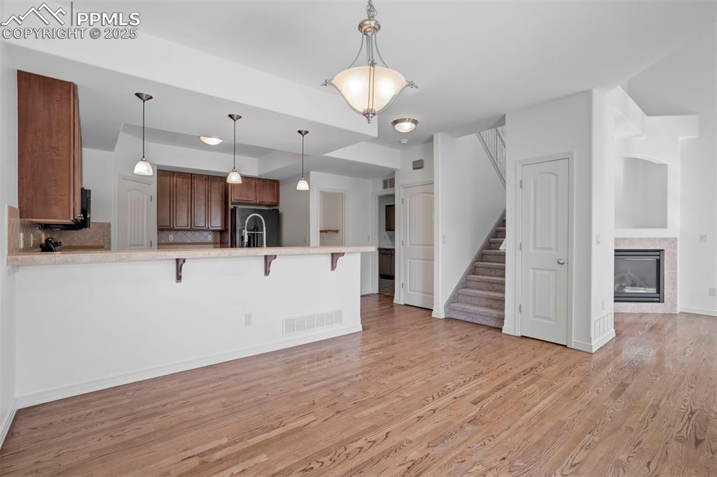 Image 8 of 50: Kitchen featuring a kitchen breakfast bar, light countertops, a peninsula,