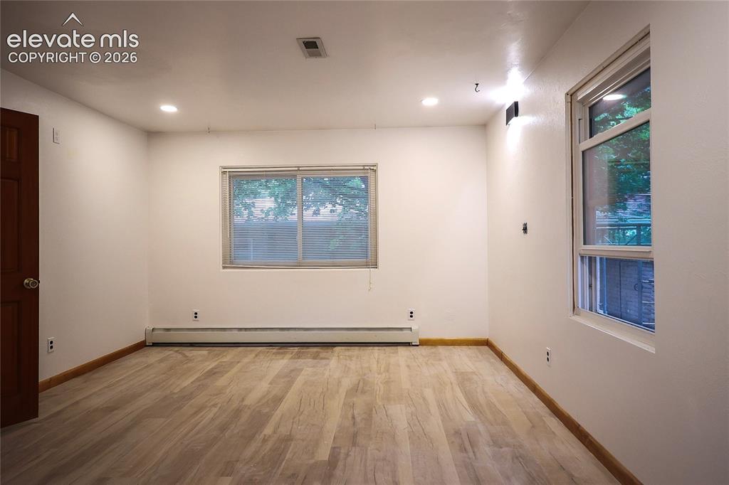 Image 24 of 40: Main bedroom Recessed ceiling lighting, wood-finish flooring, baseboard hea