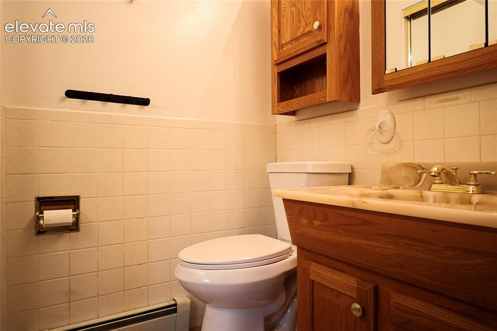 Image 34 of 40: Small bath in bed 2 built-in vanity with wood-finish cabinetry, integrated 