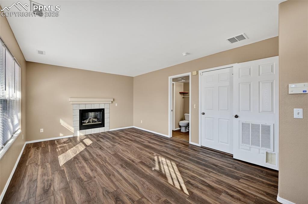 Image 15 of 30: Family room with dark wood finished floors and a tile Gas fireplace