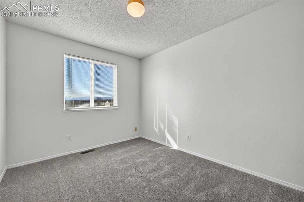 Image 21 of 30: Bedroom featuring carpet floors and a textured ceiling