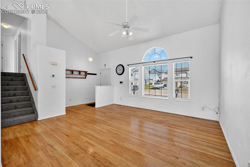 Image 8 of 30: Unfurnished living room featuring light wood-style floors, stairs, a ceilin