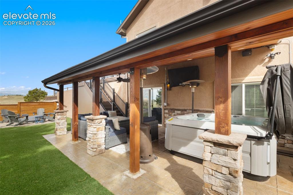 Image 31 of 40: Outdoor Entertainment area tv, outdoor speakers, hot tub, ceiling fan, rece