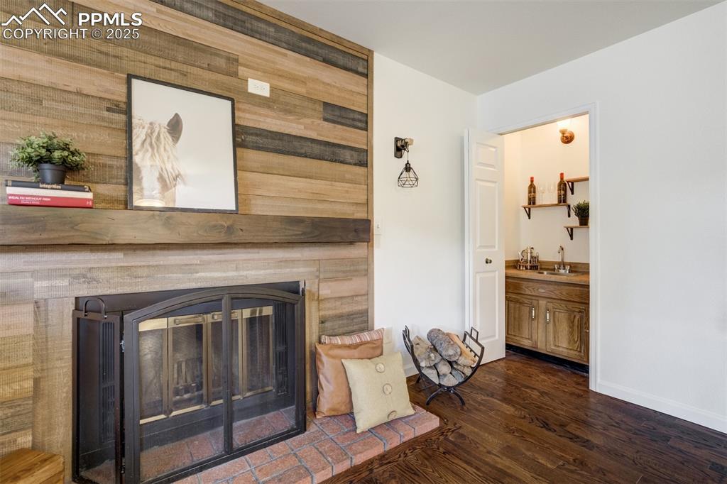 Image 10 of 50: A wet bar in living room next to fireplace