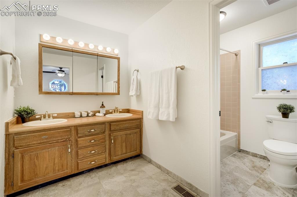 Image 23 of 50: Large Primary bathroom with double vanity and door to tub/shower/bath