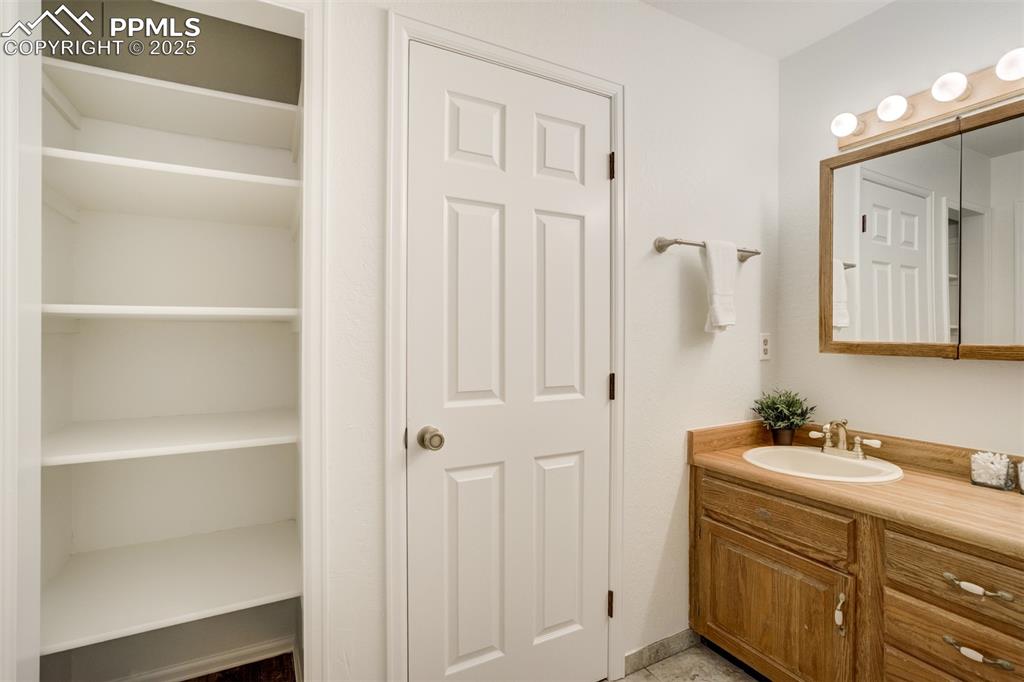 Image 24 of 50: Primary bathroom with linen closet and door to walk-in closet 