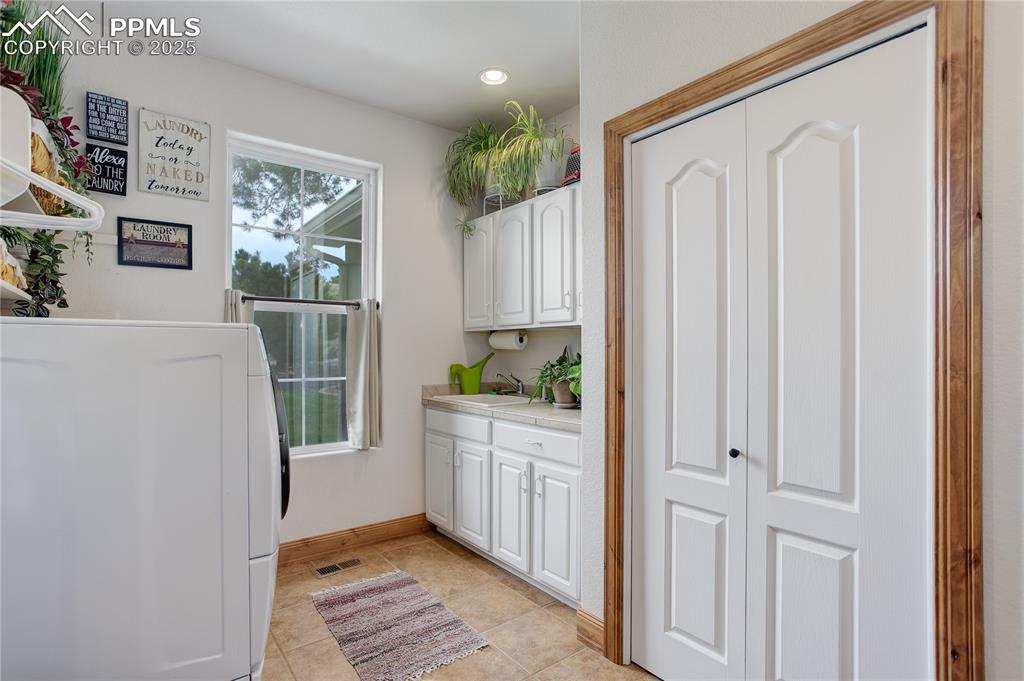 Image 21 of 41: Utility sink plus cabinet & closet storage