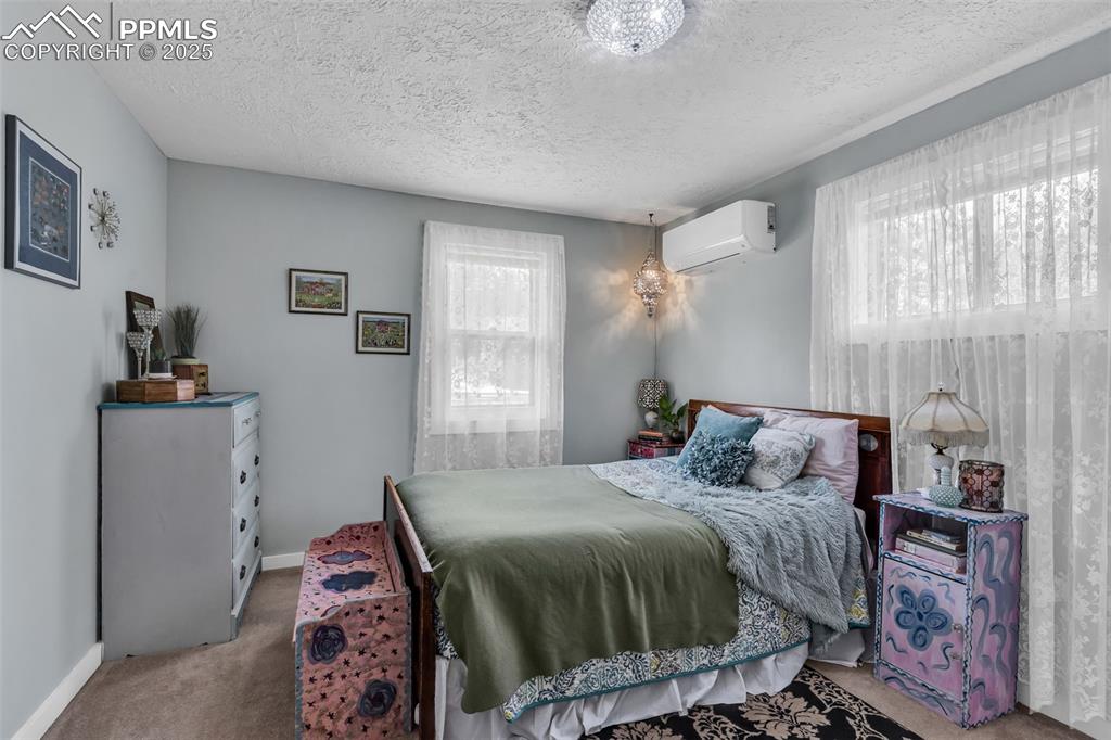 Image 18 of 44: The spacious master bedroom has windows to the west and north. 