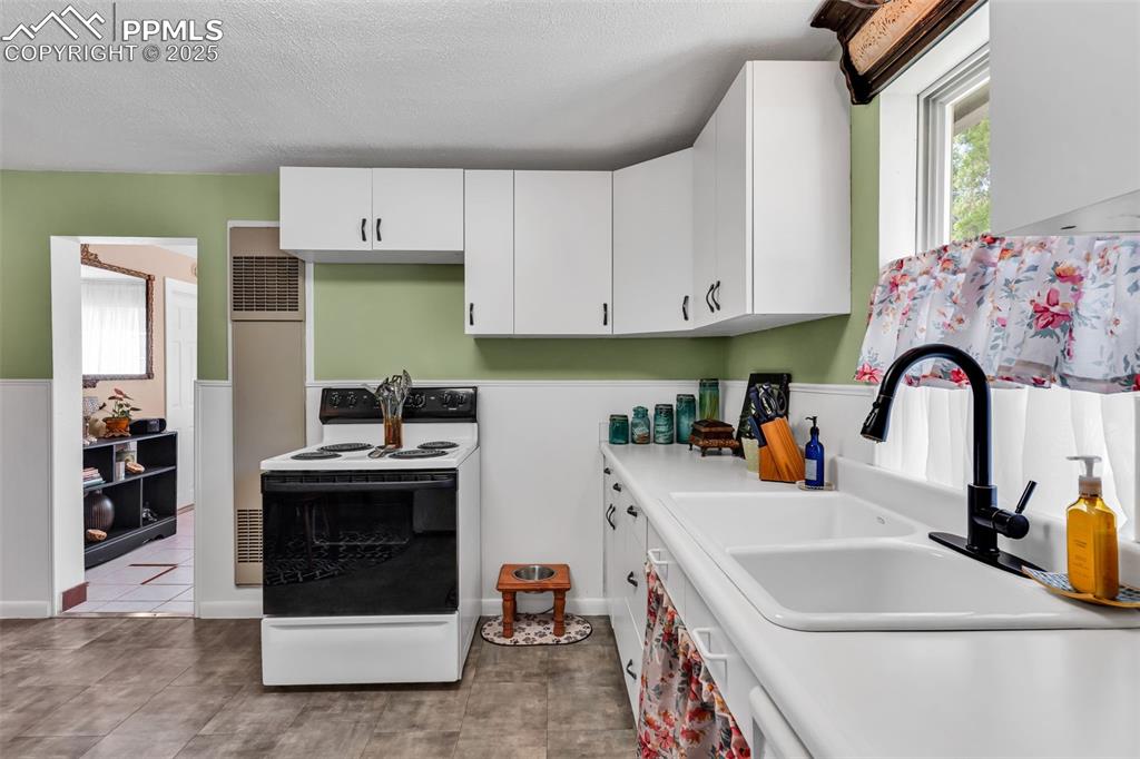 Image 19 of 44: The kitchen opens to the living room and entry. 