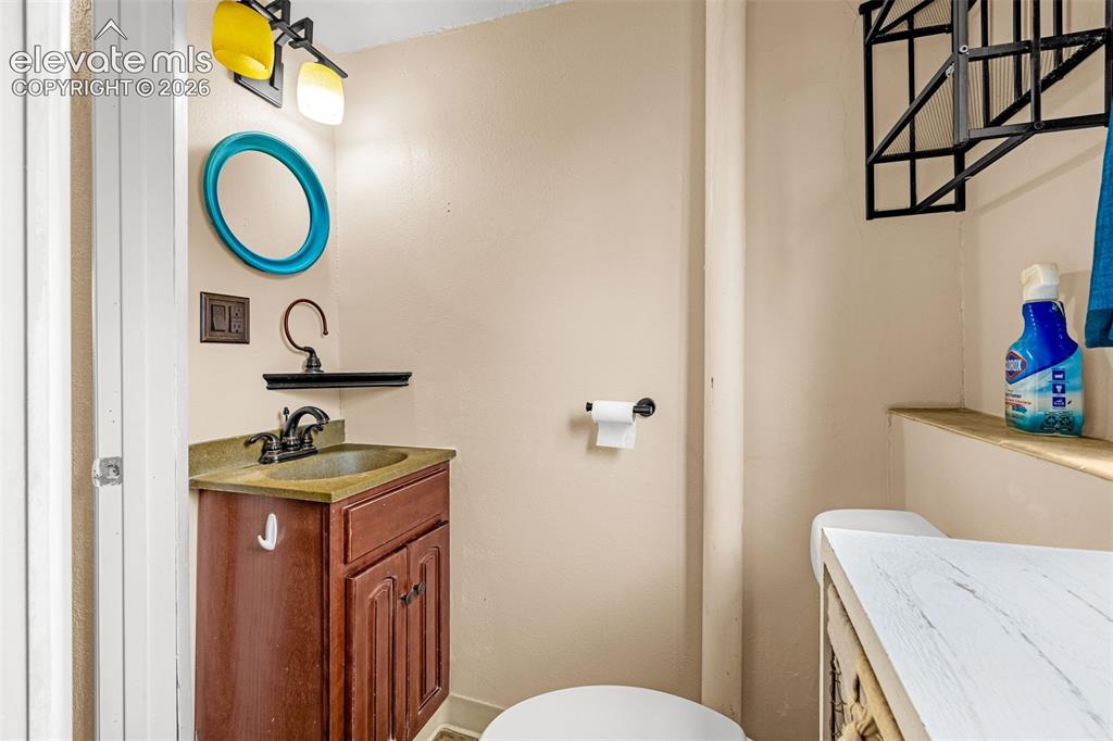 Image 18 of 30: Wood-finish vanity with a stone-composite surface, oil-rubbed bronze faucet