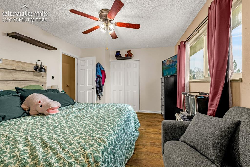 Image 20 of 30: Room featuring wood-finish flooring, a ceiling fan with integrated lighting