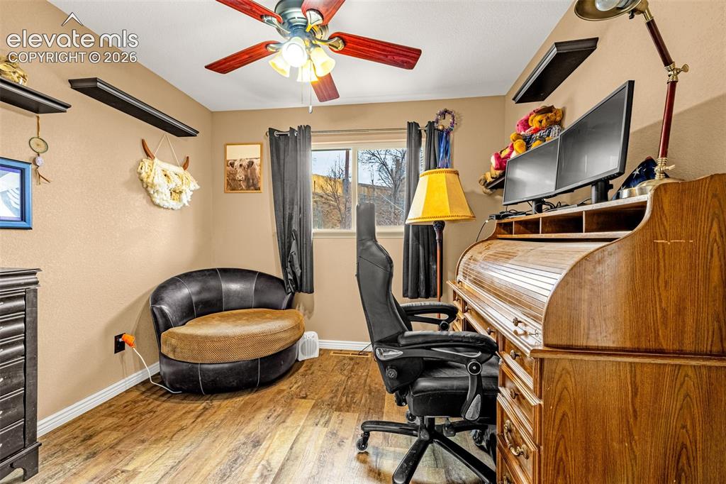 Image 21 of 30: Wood-finish flooring, ceiling fan with integrated lighting, and floating wa