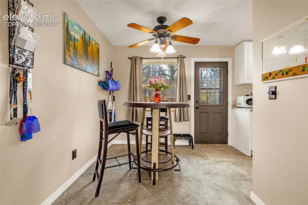 Image 7 of 30: Textured tile flooring, ceiling fan with integrated lighting, and a multi-p