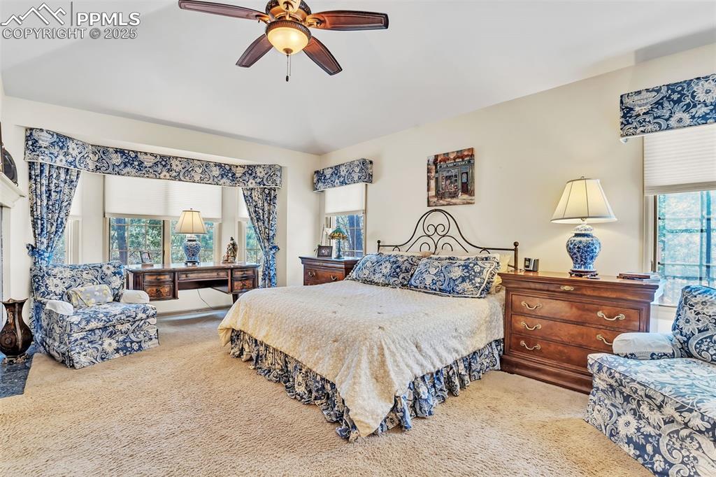 Image 15 of 45: Carpeted bedroom with vaulted ceiling and ceiling fan