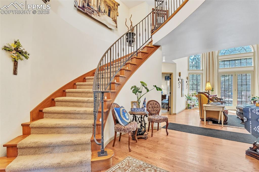 Image 20 of 45: Stairs with a high ceiling and wood finished floors