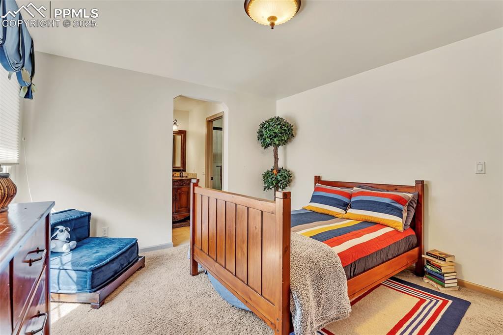 Image 30 of 45: Carpeted bedroom featuring baseboards and connected bathroom