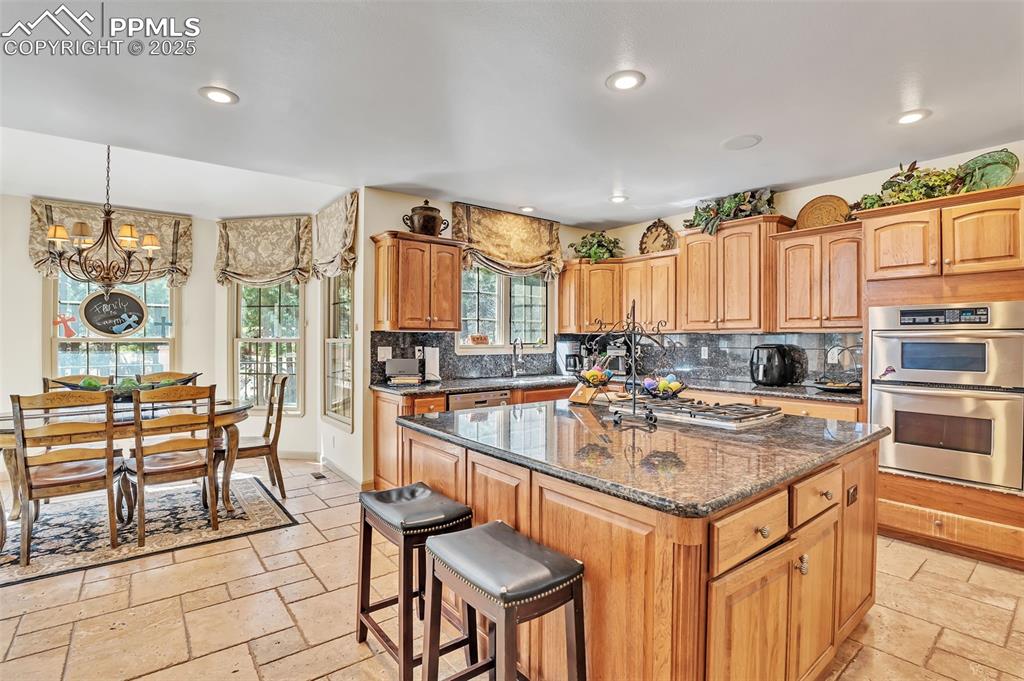 Image 8 of 45: Kitchen featuring recessed lighting, plenty of natural light, stone tile fl