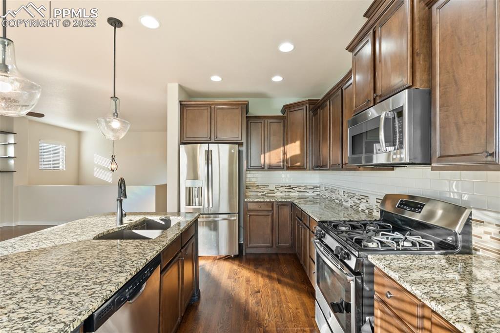Image 11 of 43: Kitchen featuring stainless steel appliances, decorative light fixtures, li
