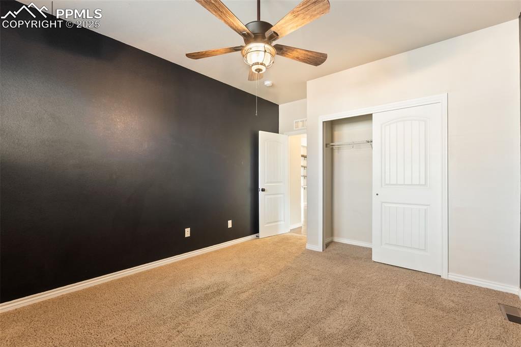 Image 17 of 43: Unfurnished bedroom with light carpet, a closet, and a ceiling fan