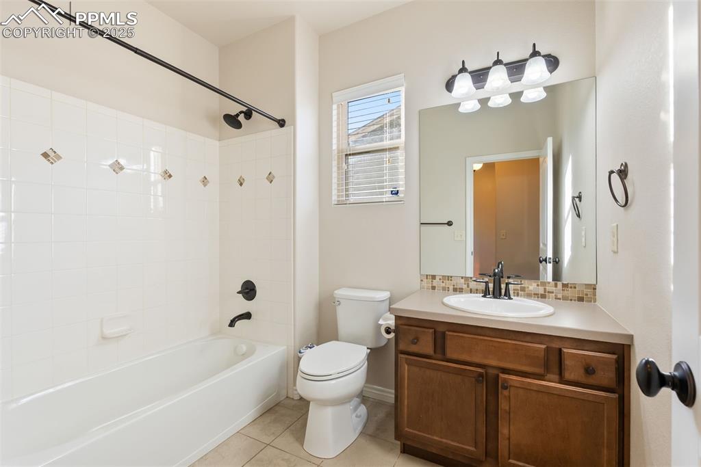 Image 18 of 43: Full bath featuring shower / bathtub combination, vanity, light tile patter