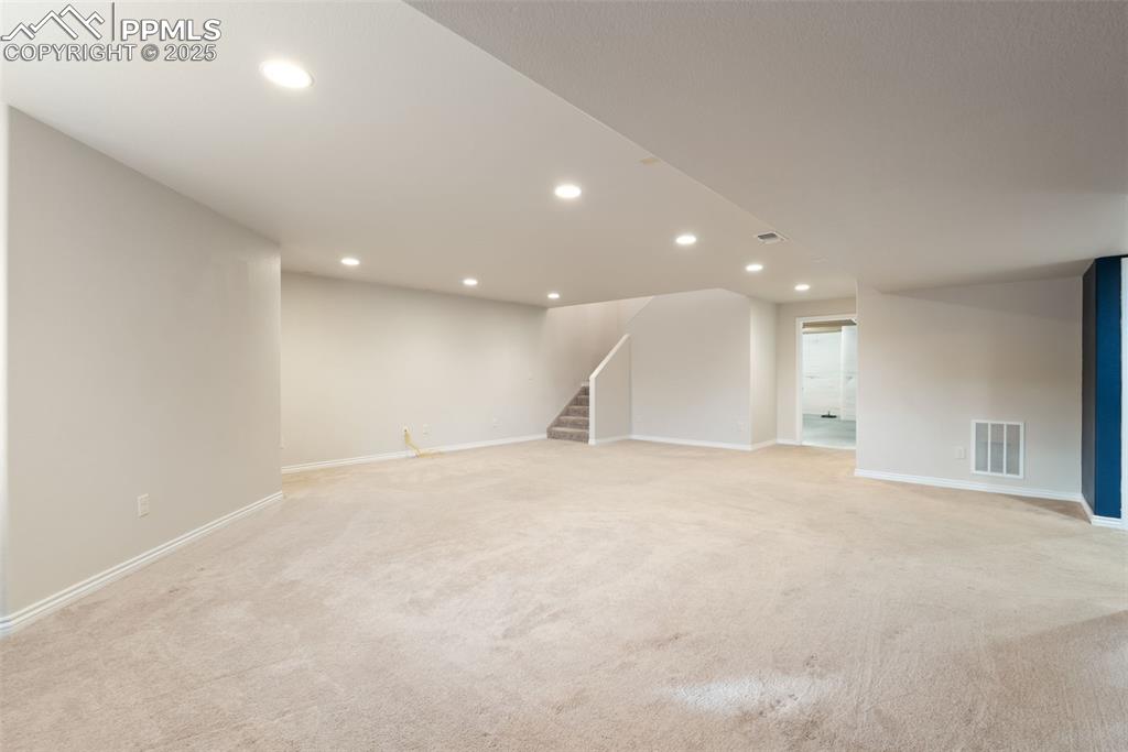 Image 29 of 43: Finished basement featuring recessed lighting, light carpet, and stairway