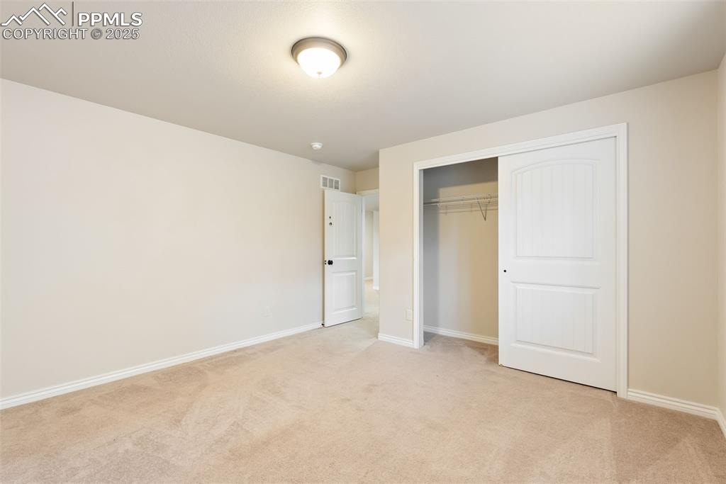 Image 32 of 43: Unfurnished bedroom featuring light carpet and a closet