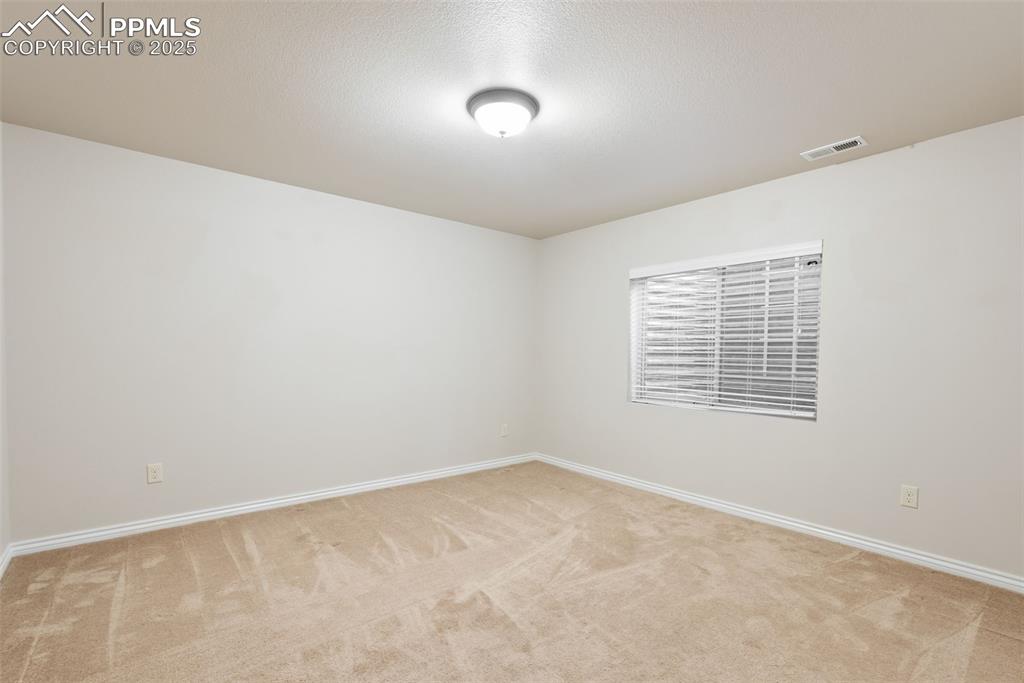 Image 34 of 43: Empty room with light colored carpet and a textured ceiling