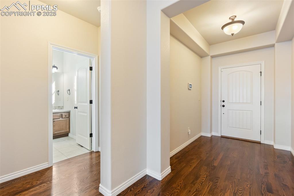 Image 7 of 43: Entrance foyer with dark wood-style flooring and baseboards
