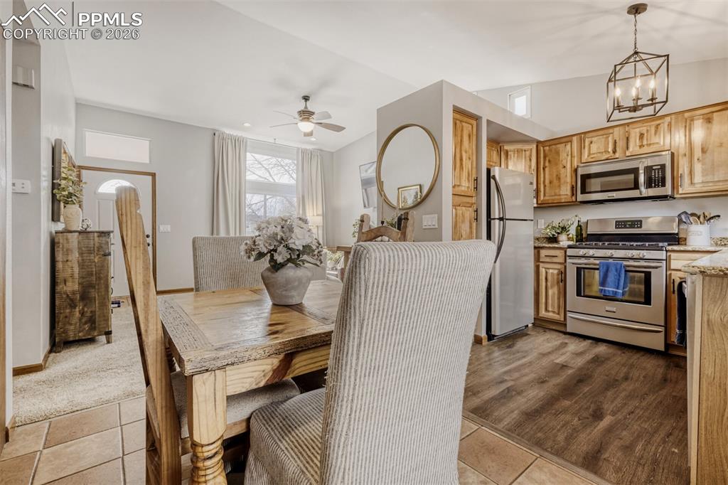 Image 11 of 27: Dining area with ceiling fan and suspended lighting