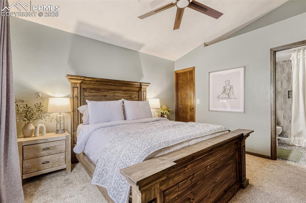 Image 20 of 27: Bedroom featuring light carpet, vaulted ceiling, and ceiling fan