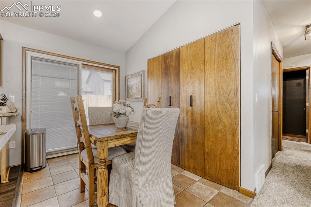 Image 6 of 27: Dining space with vaulted ceiling, light tile patterned floors, recessed li