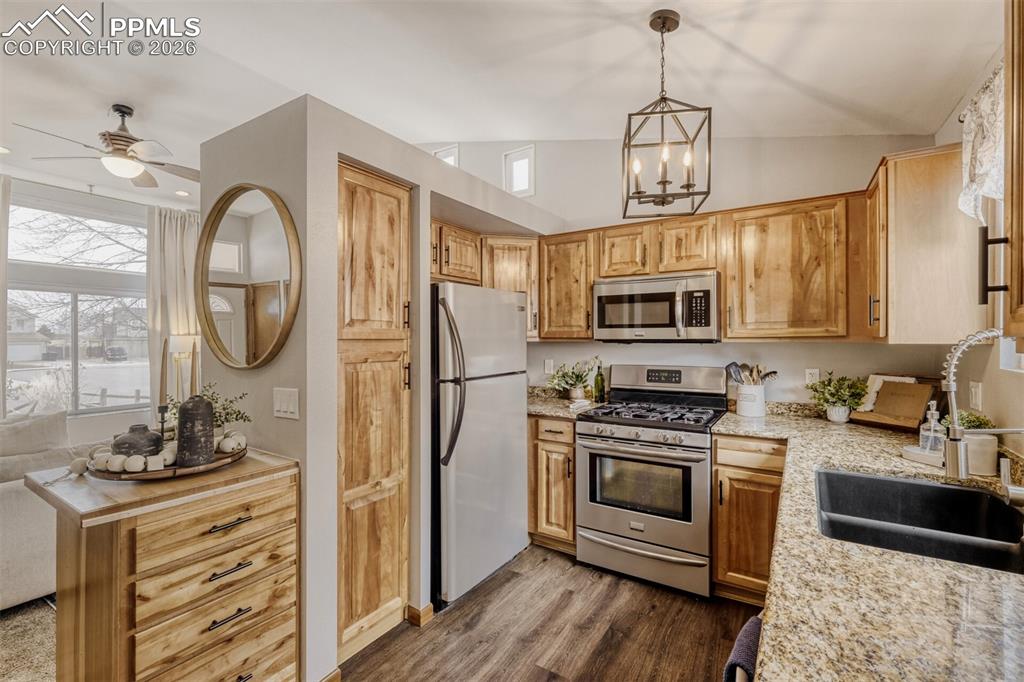 Image 9 of 27: Kitchen featuring stainless steel appliances, ceiling fan, dark wood finish