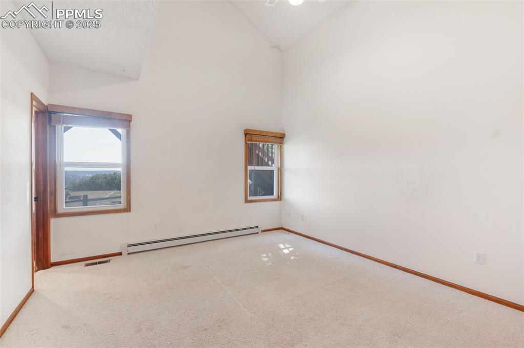 Image 24 of 50: Carpeted Bedroom.  Notice All Windows Are Wood Framed! Vaulted Ceiling